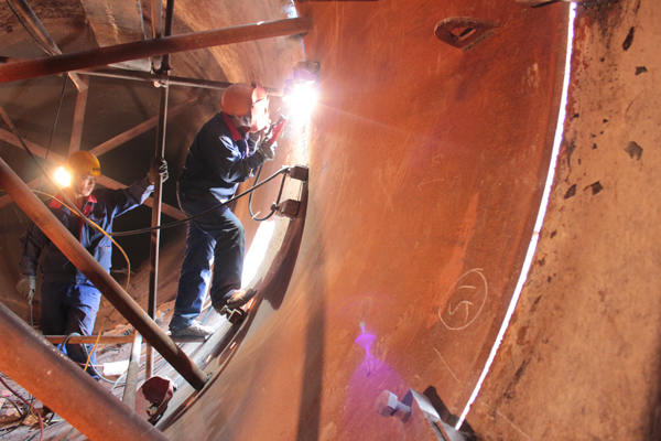 工人對(duì)回轉(zhuǎn)窯窯內(nèi)進(jìn)行焊接